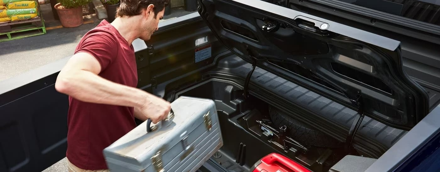A man putting a tool box in a 2025 Honda Ridgeline