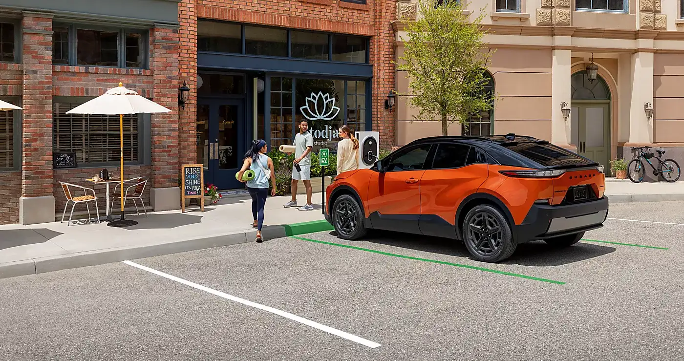 Orange compact electric SUV parked outside a café