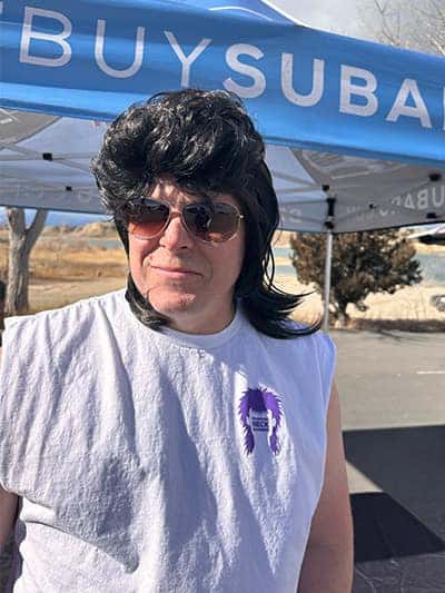 Man in a mullet wig and sunglasses at the Polar Plunge tent