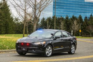 Ford Special Service Plug-In Hybrid Sedan driving down a city street