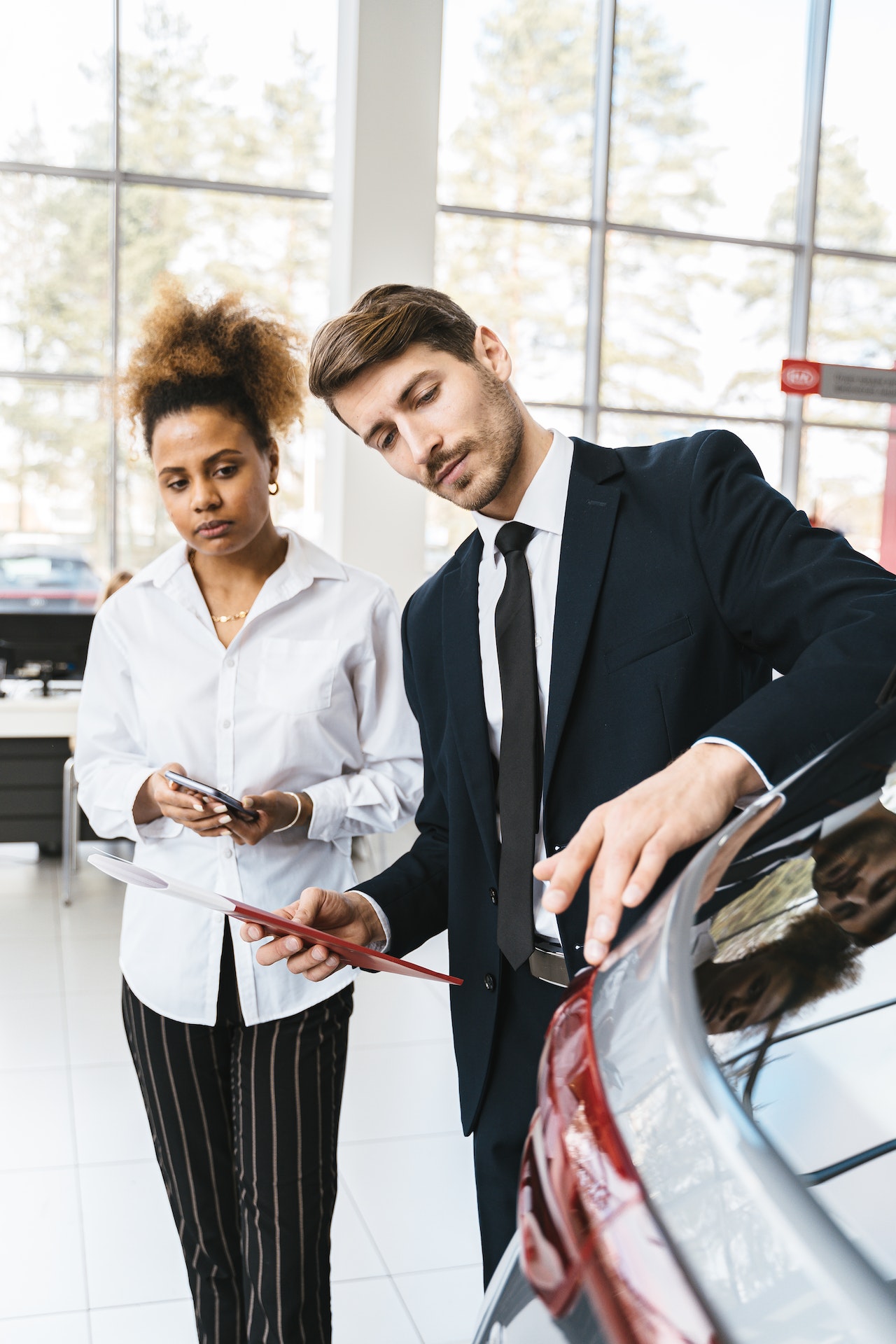 Man and Woman Inspecting Car