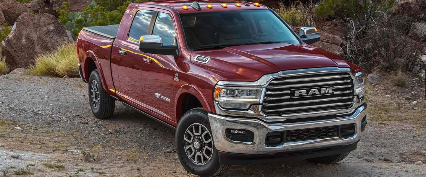 A red truck sitting on a dirt road.