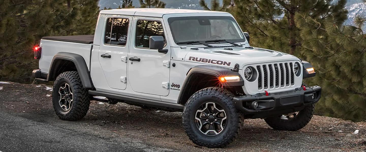 A white jeep sitting parked on a road.