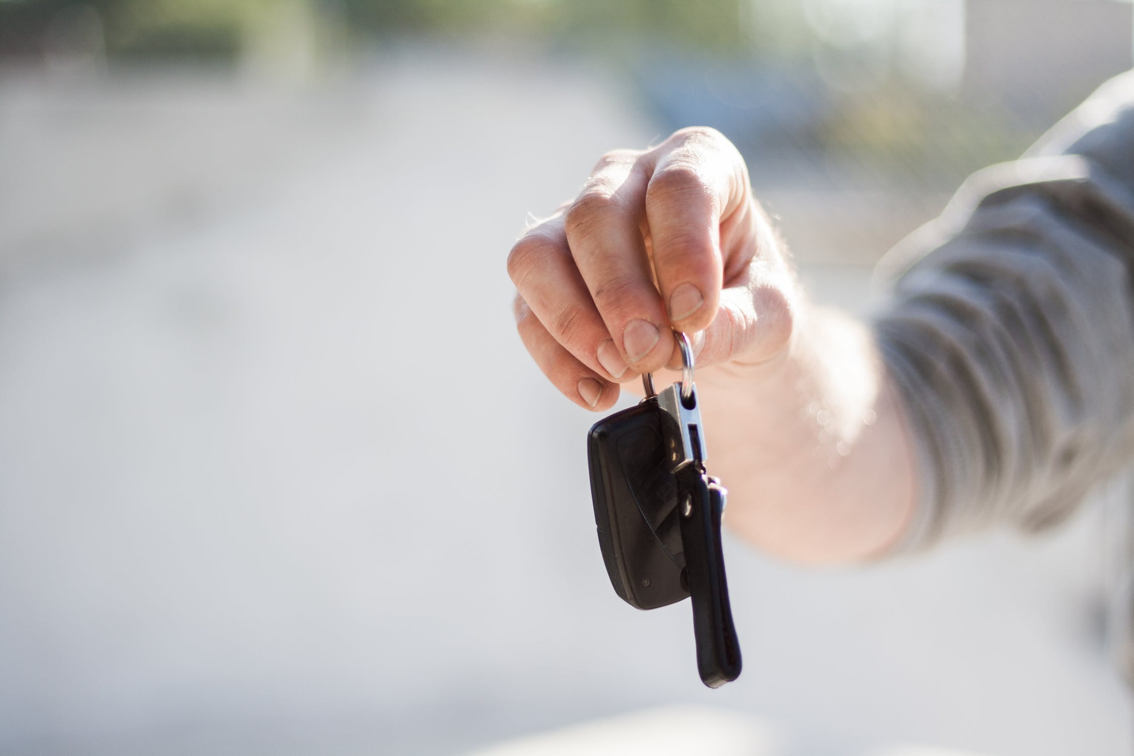 Man holding a key out to you