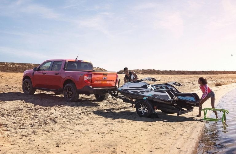 Red 2022 Ford Maverick Rear Exterior Pulling Jet Ski at a Beach