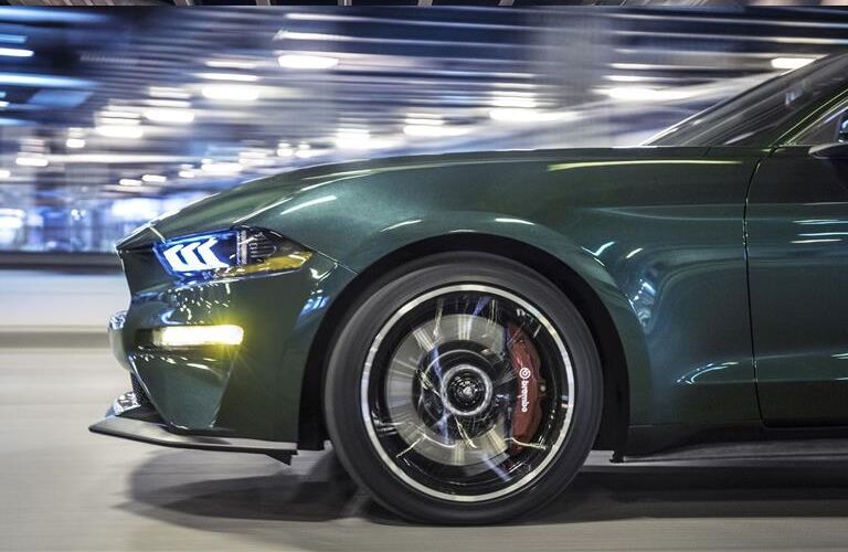 side view of the front half of a green 2019 Ford Mustang Bullitt's exterior with special emphasis on its wheel