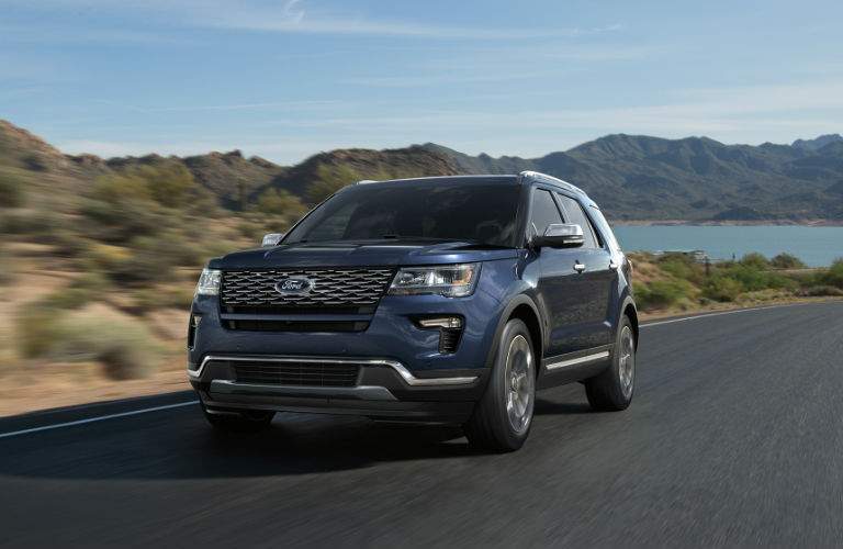 front view of a blue 2018 Ford Explorer driving along a desert highway