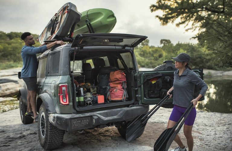 Green 2024 Ford Bronco Rear Exterior by River with Kayaks on Roof and MOLLE Panel