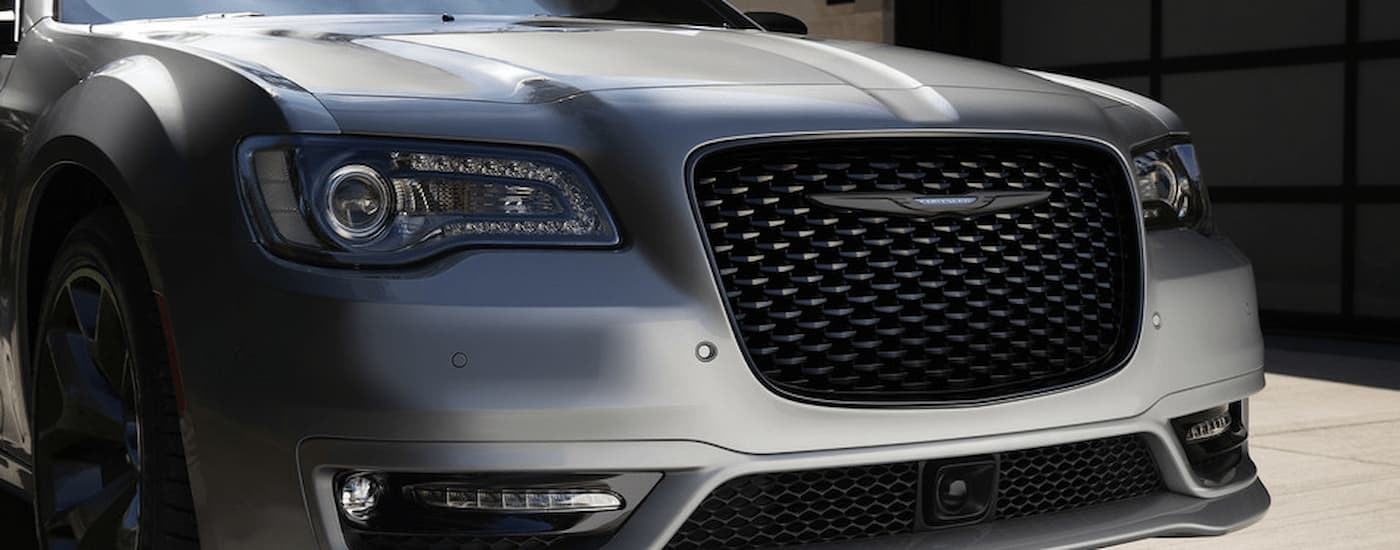 A close up of the front and grille of a silver 2021 Chrysler 300 is shown.