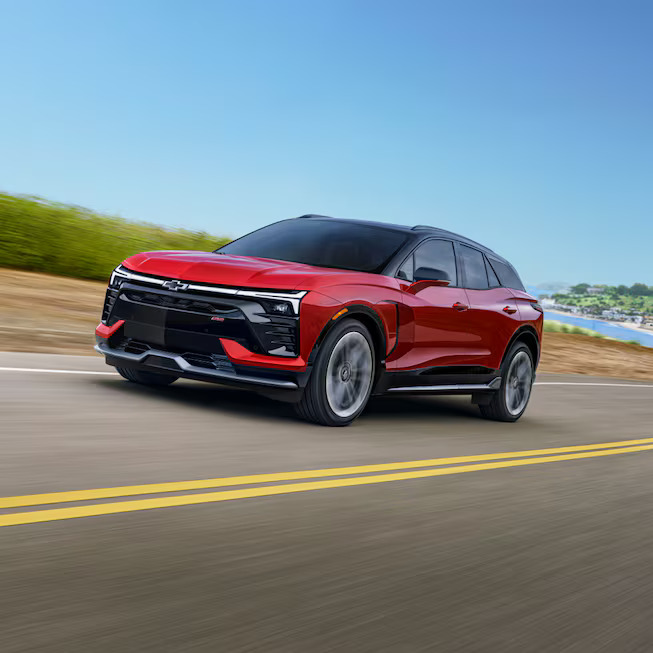 A red chevy blazer ev driving on a road.