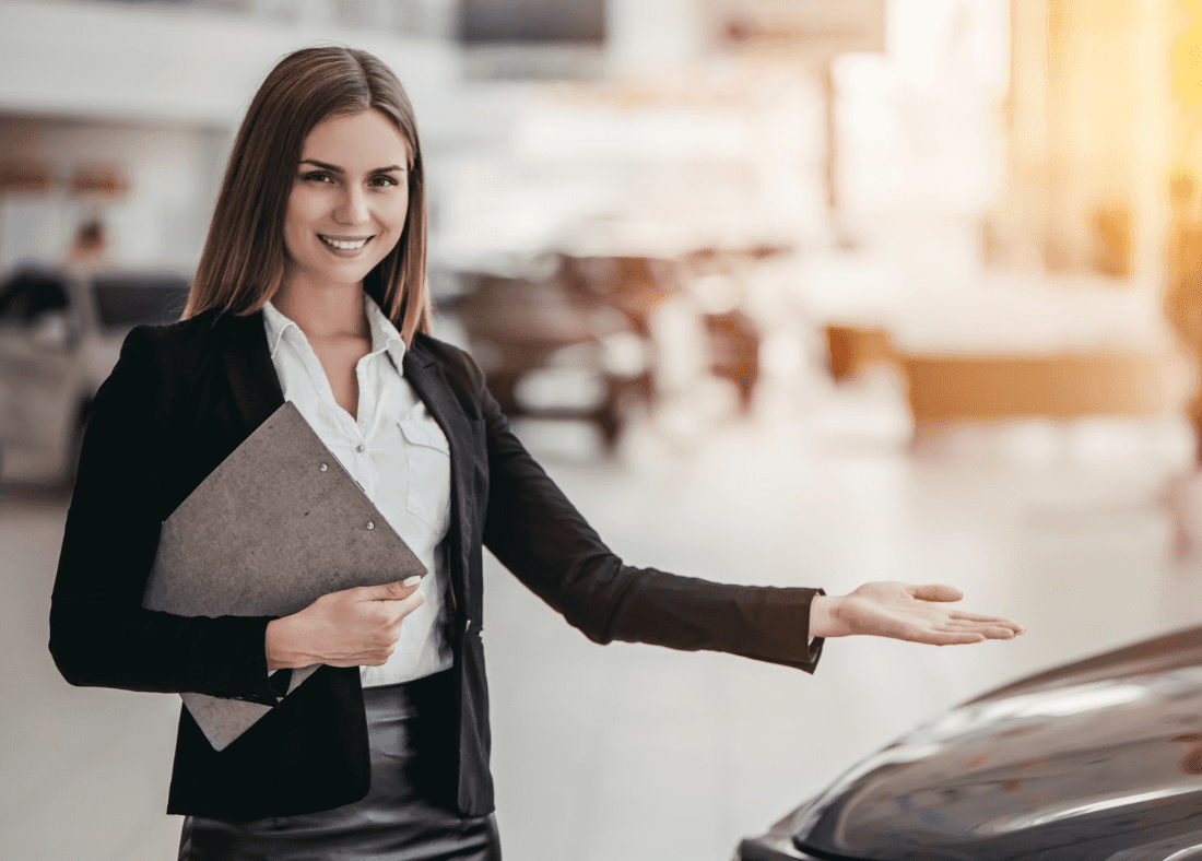 Sales representative showcasing a Kia EV in a dealership, promoting electric vehicle options and savings.
