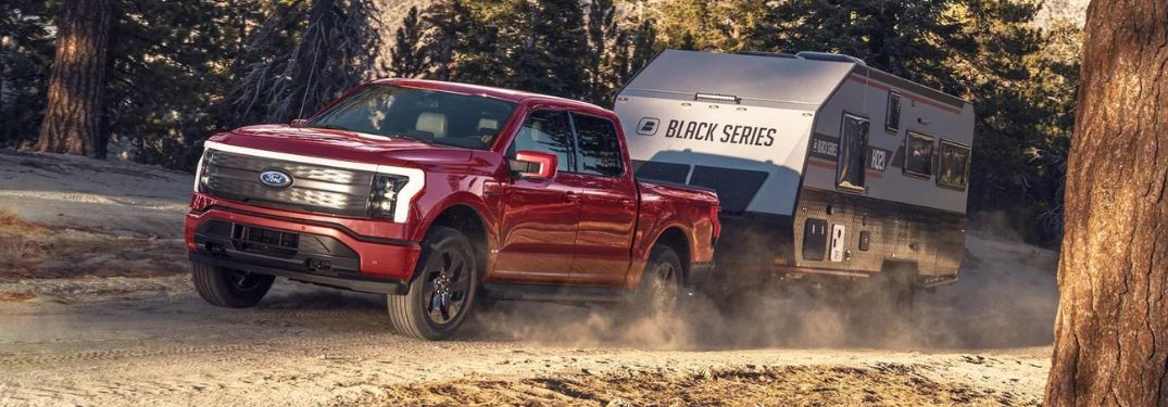 Red 2023 Ford F-150 Lightning Towing a Camper