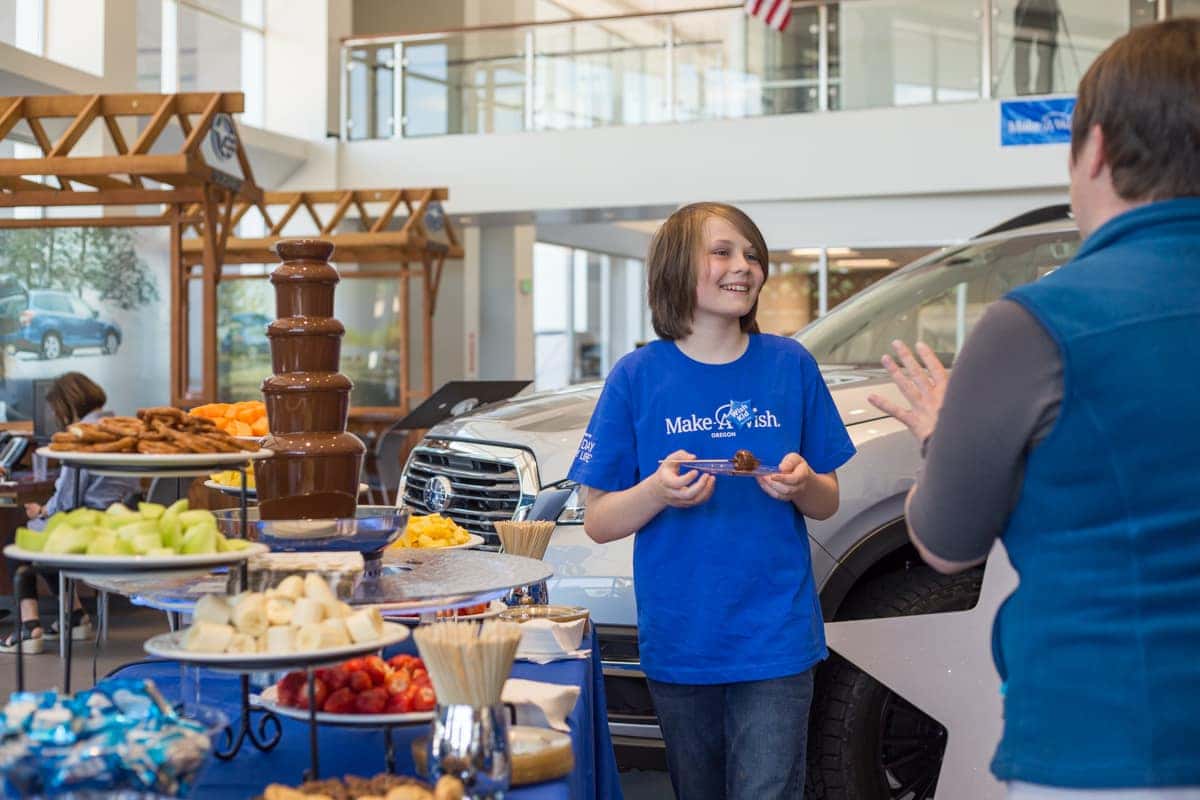 Danton speaking beside a dessert buffet in the showroom