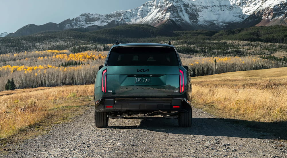 Rear of a green 2027 Kia Telluride driving off-road.