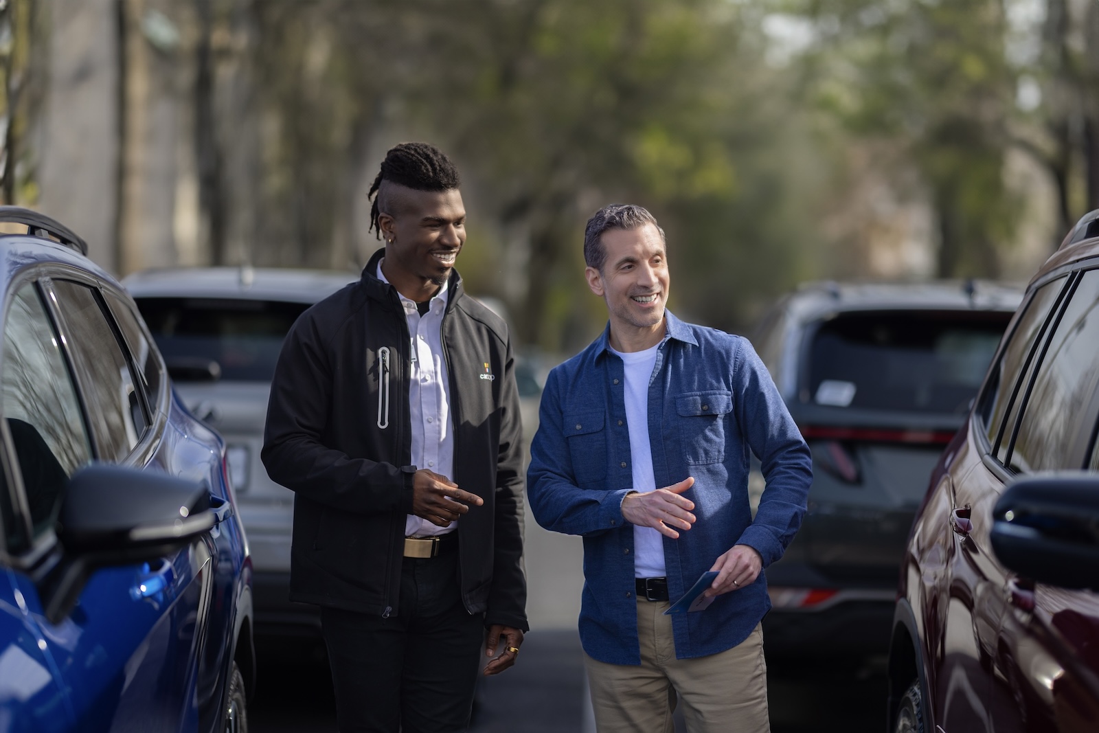 Associate and customer admiring vehicles