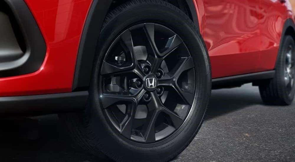 A close-up on the wheel of a red 2024 Honda HR-V Sport.