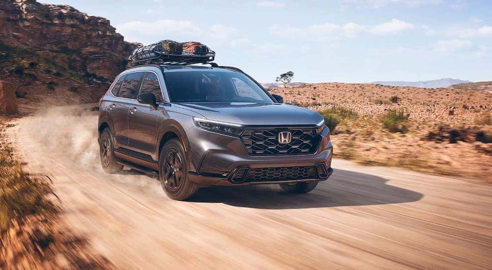Grey 2025 Honda CR-V Sport Hybrid driving off-road.