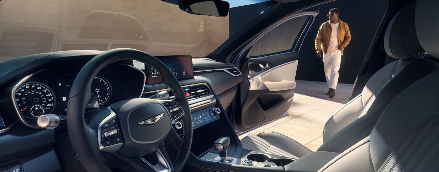 Steering wheel, center console, and open door in a 2026 Genesis G70