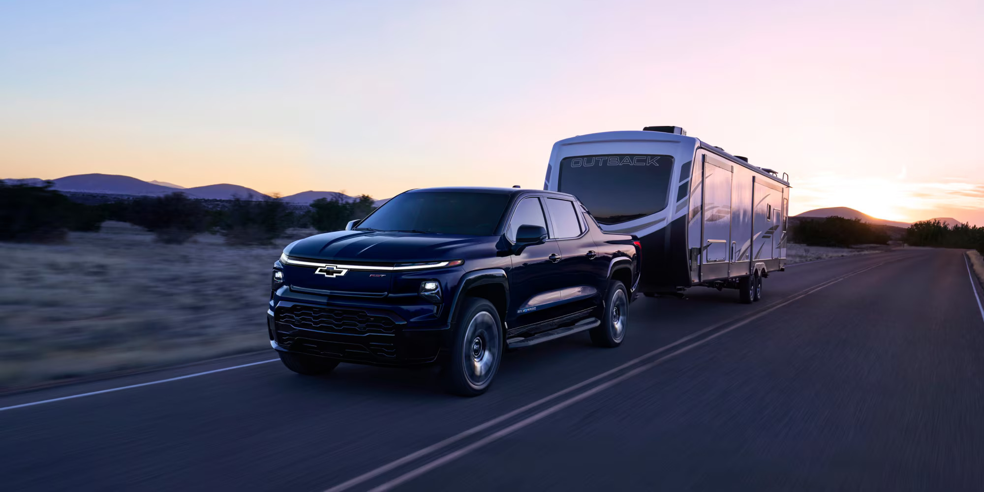 A black truck pulling a mobile home.