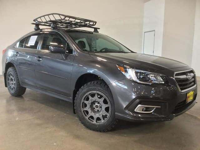 Lifted gray Subaru Legacy with off-road tires and a roof basket
