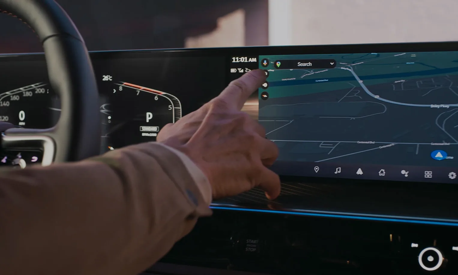 Driver’s view of the 2027 INFINITI QX80 wide dual digital display, with a hand selecting a destination on the navigation touchscreen beside the digital instrument cluster.
