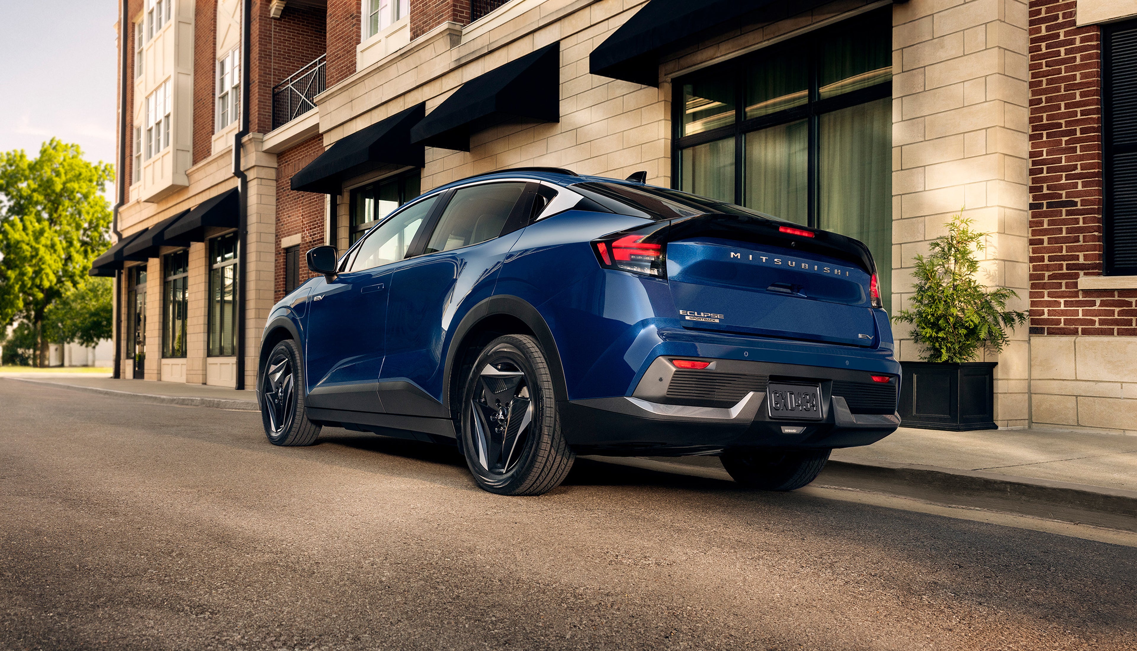 2027 Mitsubishi Eclipse Sportback EV in blue parked on a city street, rear three-quarter view