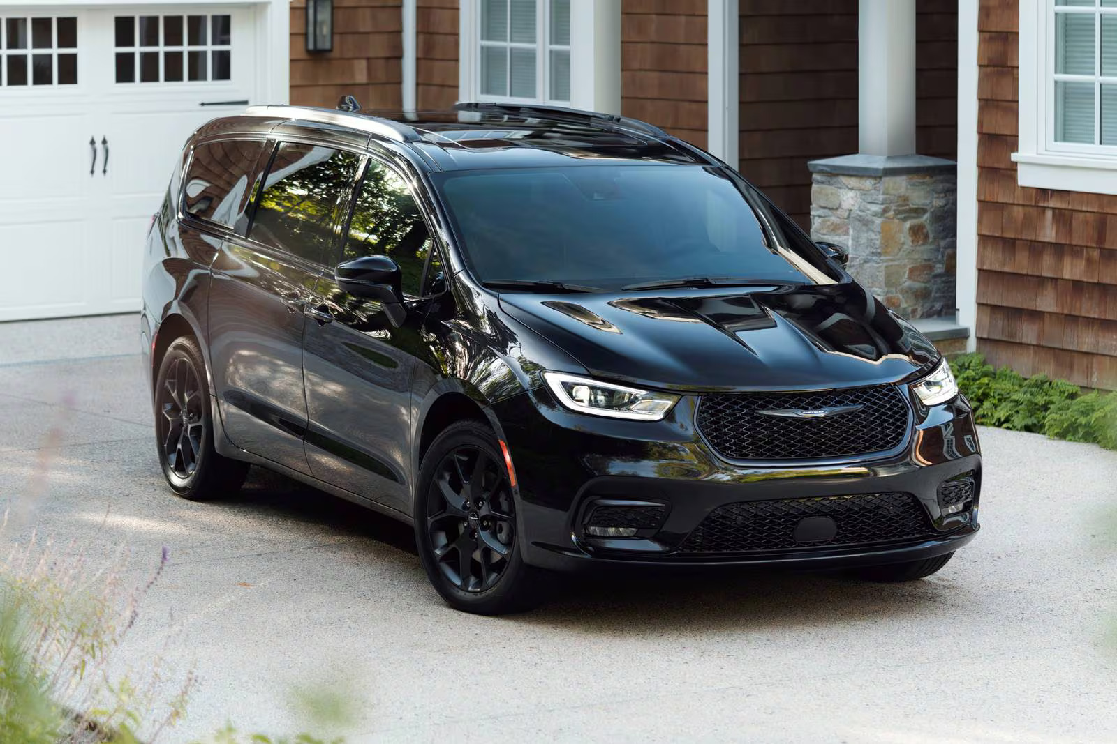 A black van sitting parked in the driveway.