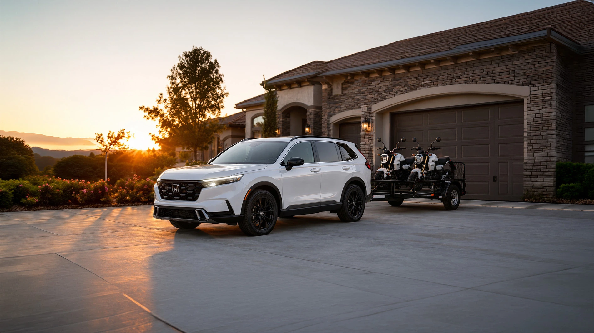 2026 Honda CR-V towing two Honda Grom motorcycles on a trailer hooked up in the driveway of a home