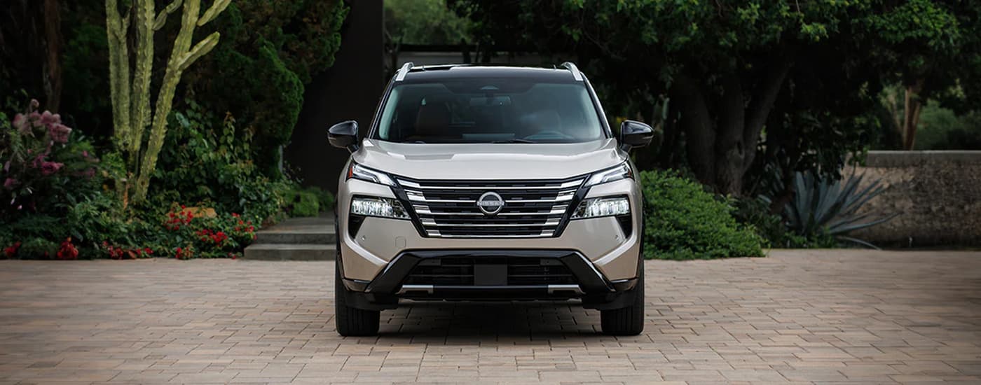 Tan 2026 Nissan Rogue parked on a brick driveway