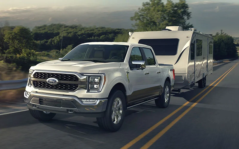 image of white ford towing camper