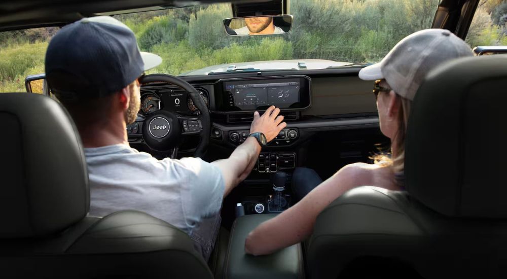 People are shown off-roading in a 2024 Jeep Gladiator for sale.