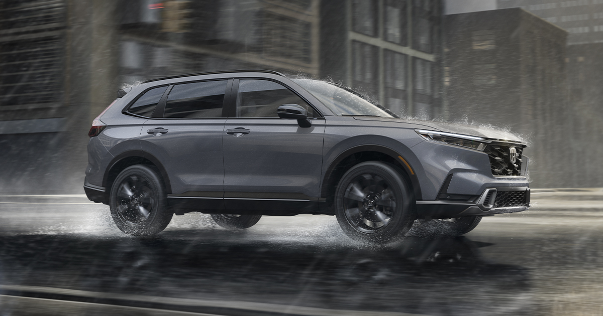 A silver 2026 Honda CR-V drives through the pouring rain.