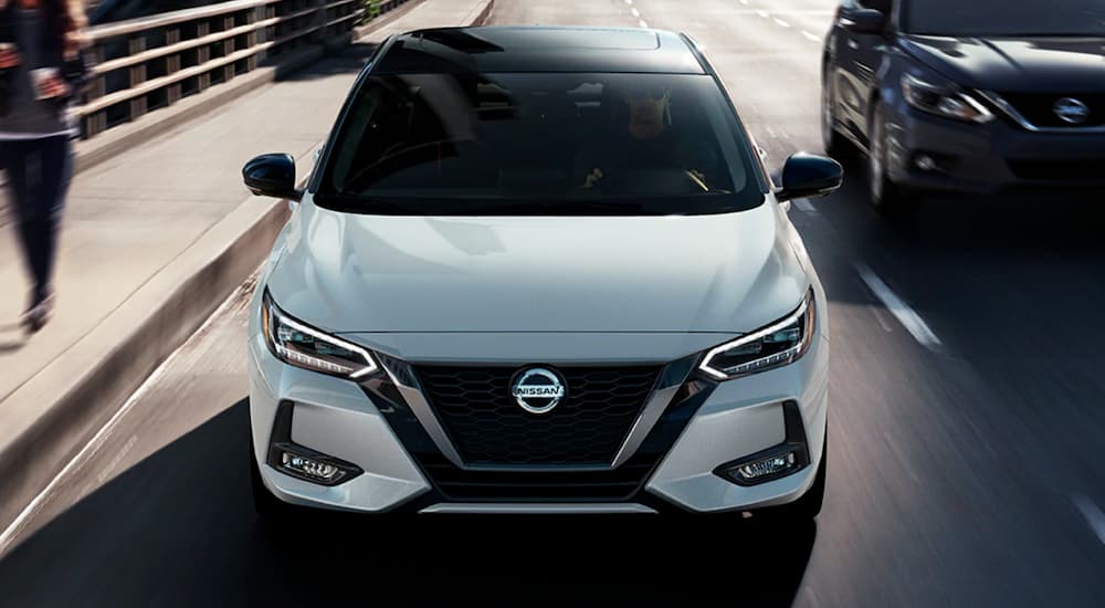 White 2021 Nissan Sentra driving to a dealership with used cars for sale near Flora Vista