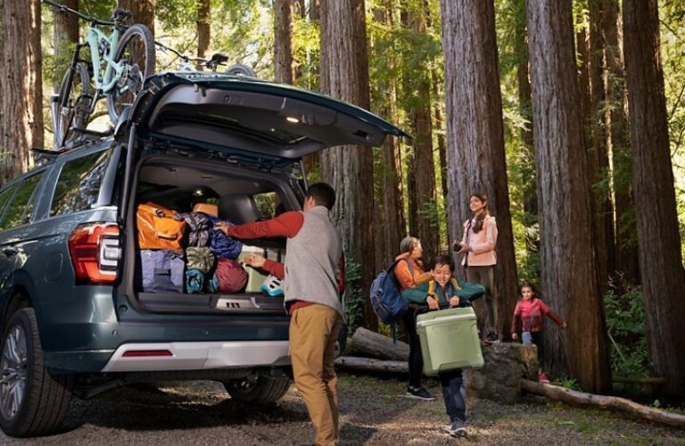 Family Packing Camping Gear into the Back of a 2024 Ford Expedition in the Woods