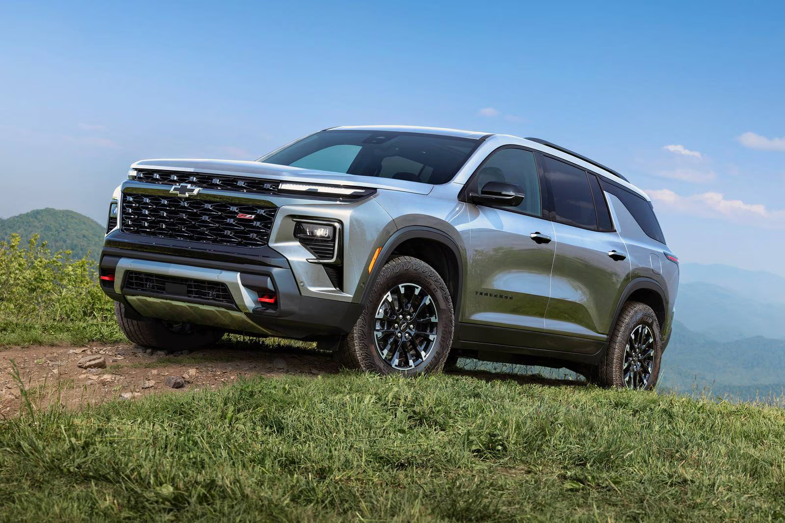 A green suv sitting parked in the grass.