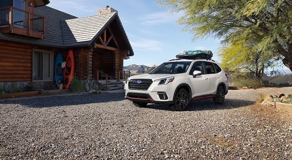 A white 2024 Subaru Forester parked outside a building.