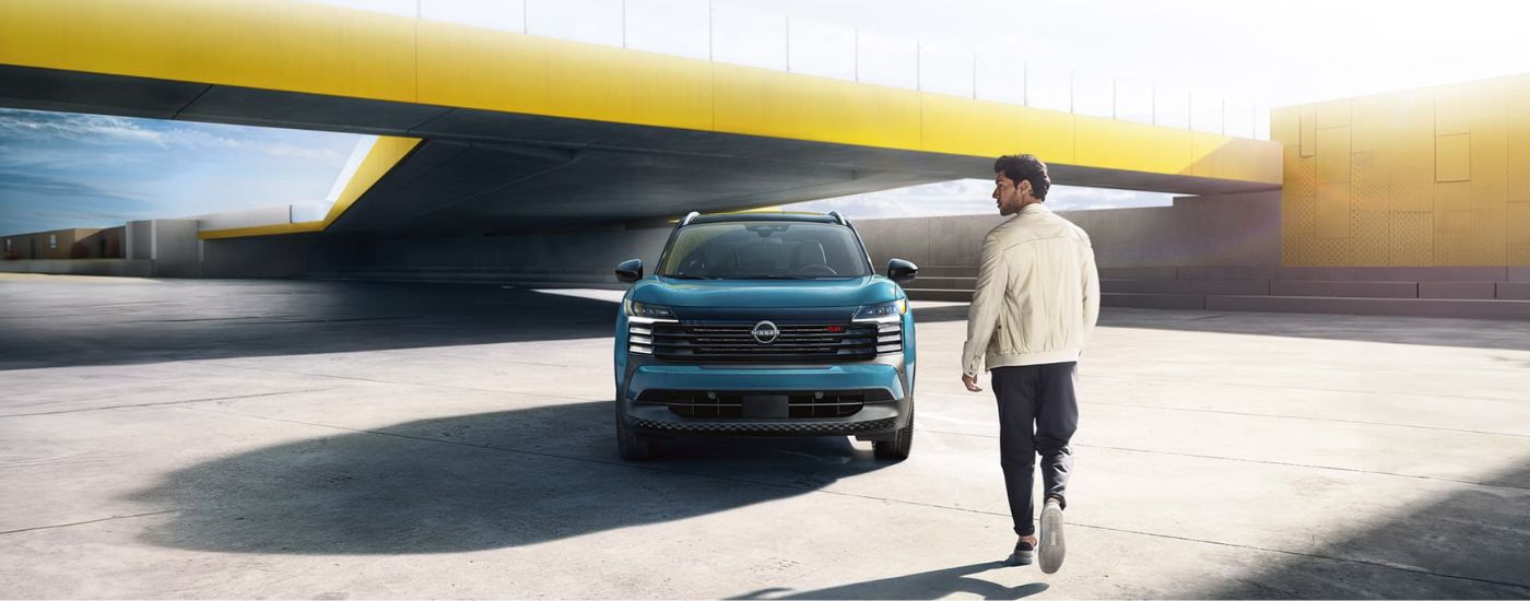 Blue 2025 Nissan Kicks SR parked near a person