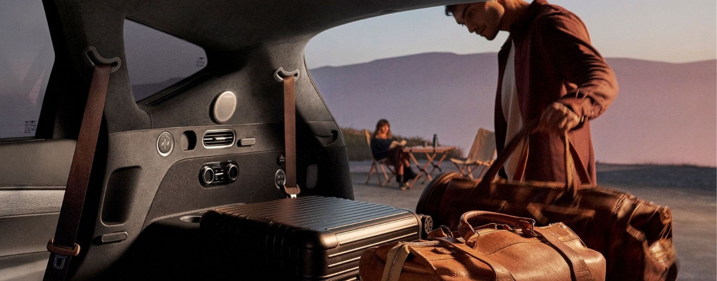 Person loading luggage in a 2025 Genesis GV80 for sale near Birmingham