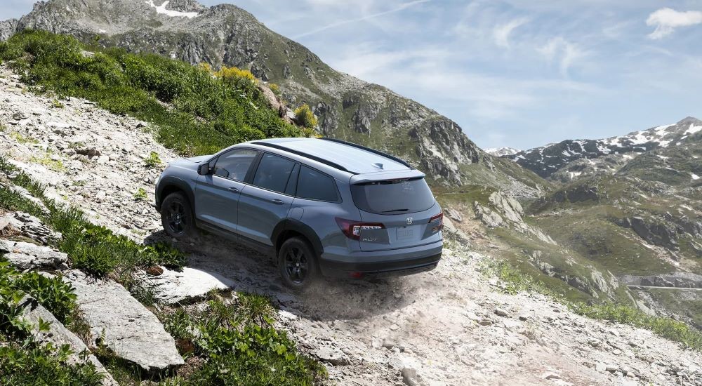 Grey 2022 Honda Pilot Trailsport driving up a dirt trail