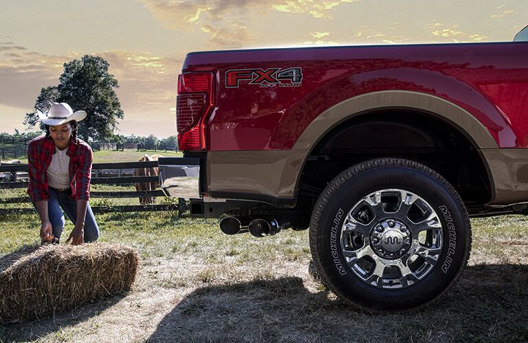 woman putting hay in the back of her red 2021 Ford F-250