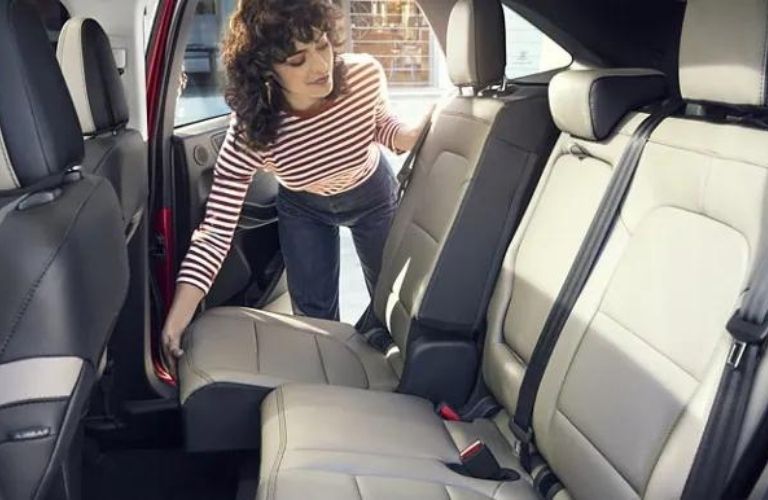 A woman moving the rear seat in the 2022 Ford Escape.