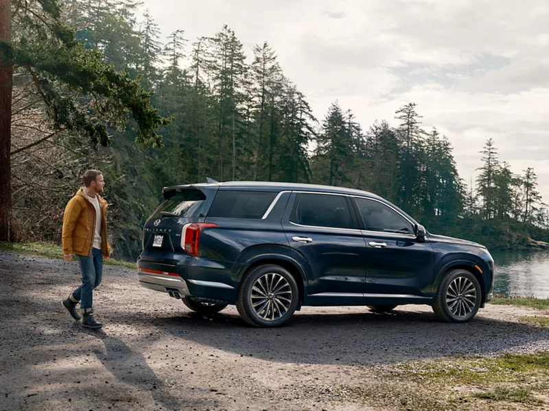 A man walking over to a Hyundai Palisade.