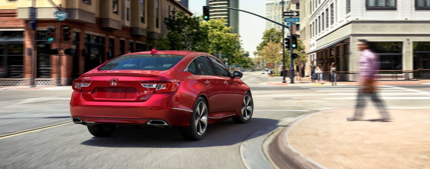 Red 2020 Honda Accord Touring driving around a corner on a city street