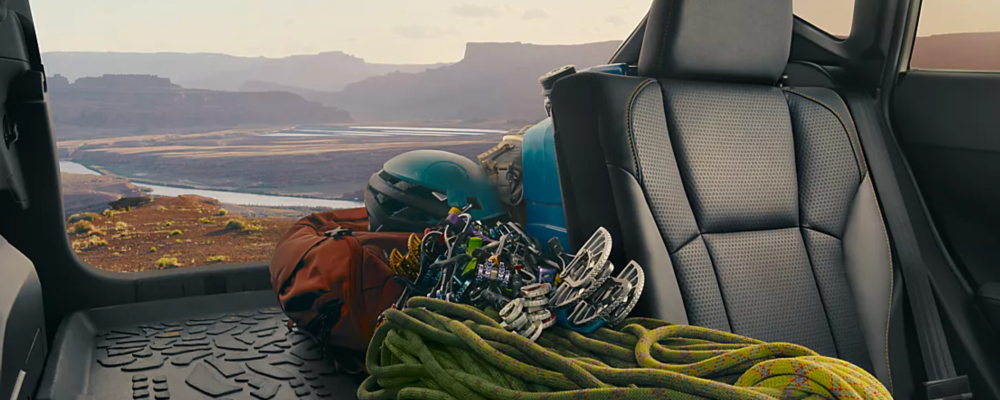The back cargo area of the SUV is carrying ropes and helmets for climbing.
