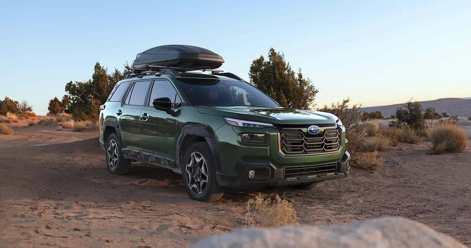 Green 2026 Subaru Outback with a roof cargo box in the desert