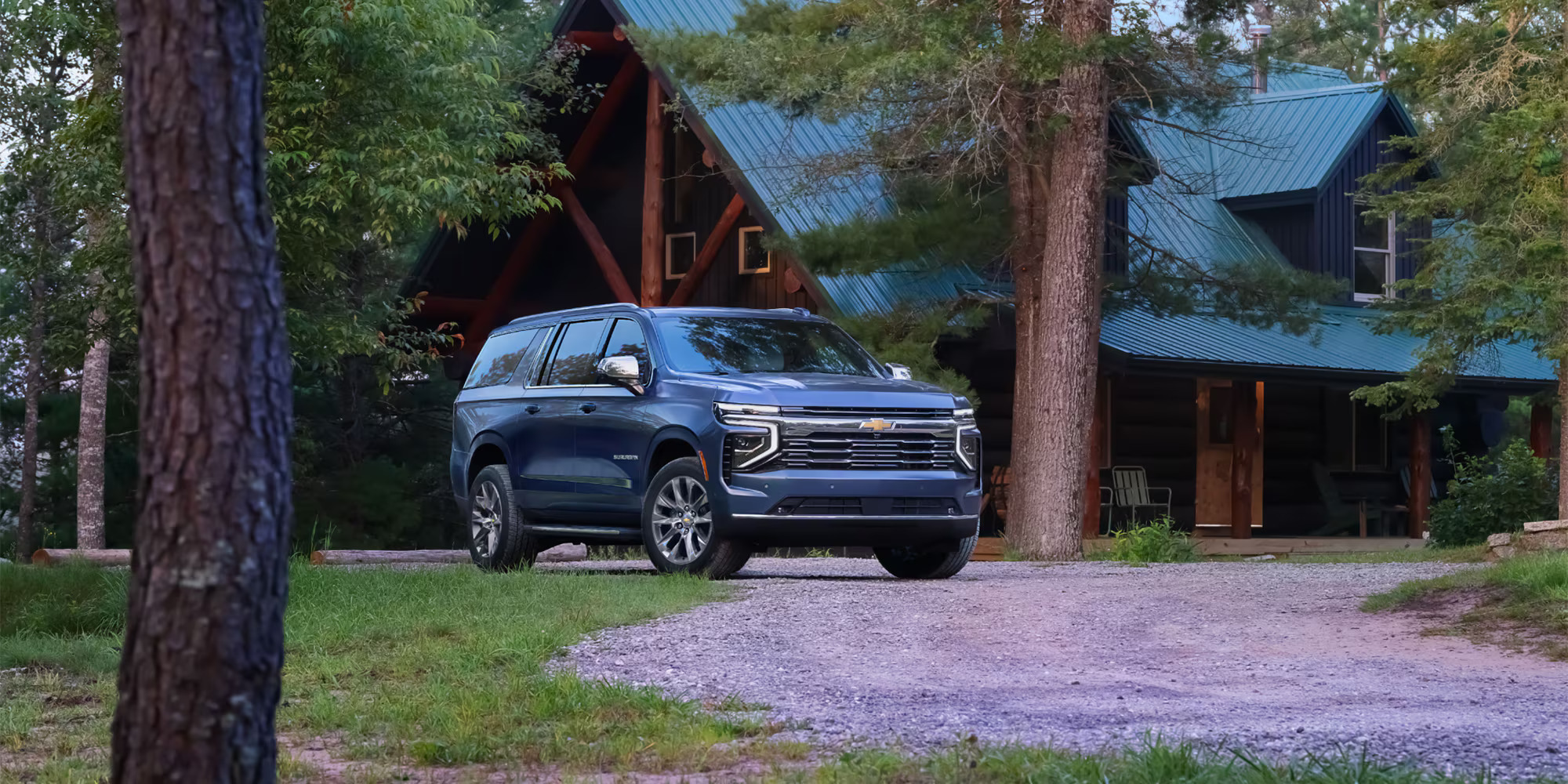 A blue suv sitting parked in front of a house.