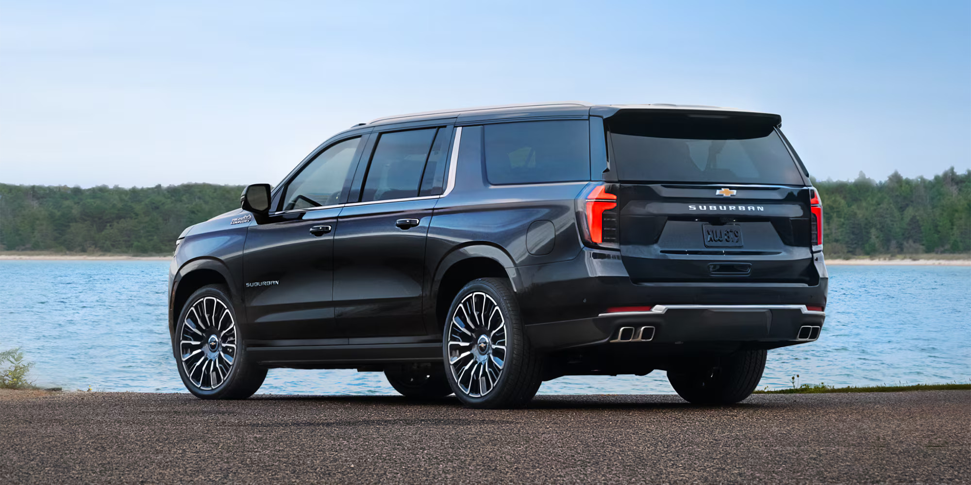 A black suv parked in front of water.