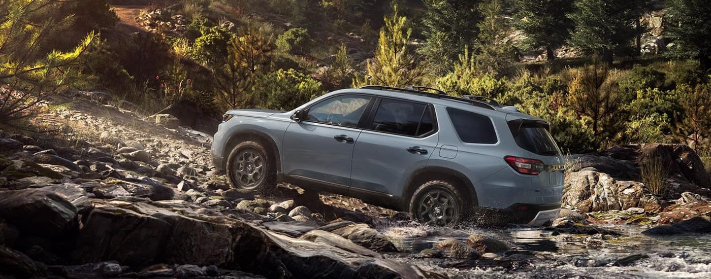 Gray 2024 Honda Pilot is shown driving off-road
