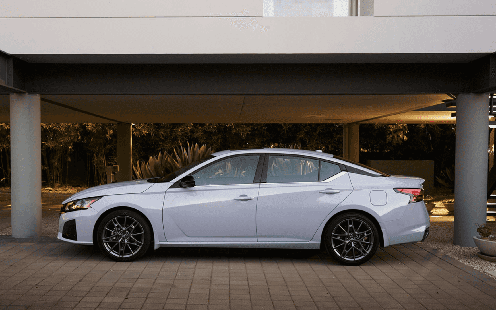 Silver Nissan Altima parked under a modern carport
