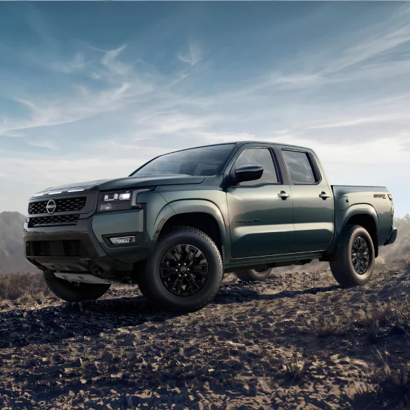 2027 Nissan Frontier in dark green, front three-quarter view off-road